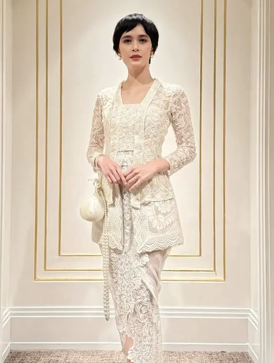 Renata tampil mengenakan kebaya putih lace warna putih dari Toton the Label dipadukan dengan bawahan kain berbordiran sambil membawa tas bulat putih ini. [@renata711]